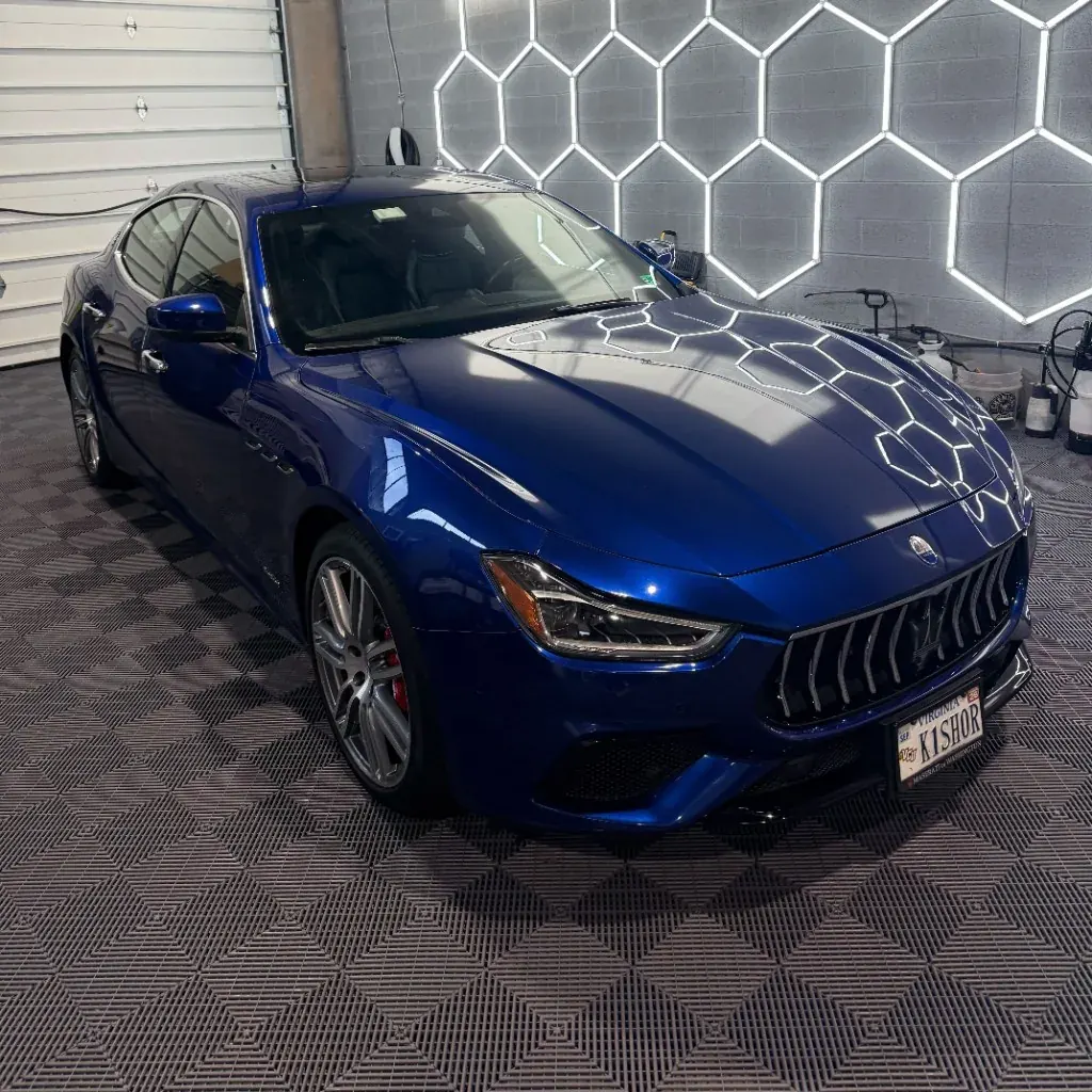Blue Maserati after a ceramic coating under hexagon shop lights