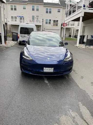 Blue Tesla Model 3 on a driveway after a detail