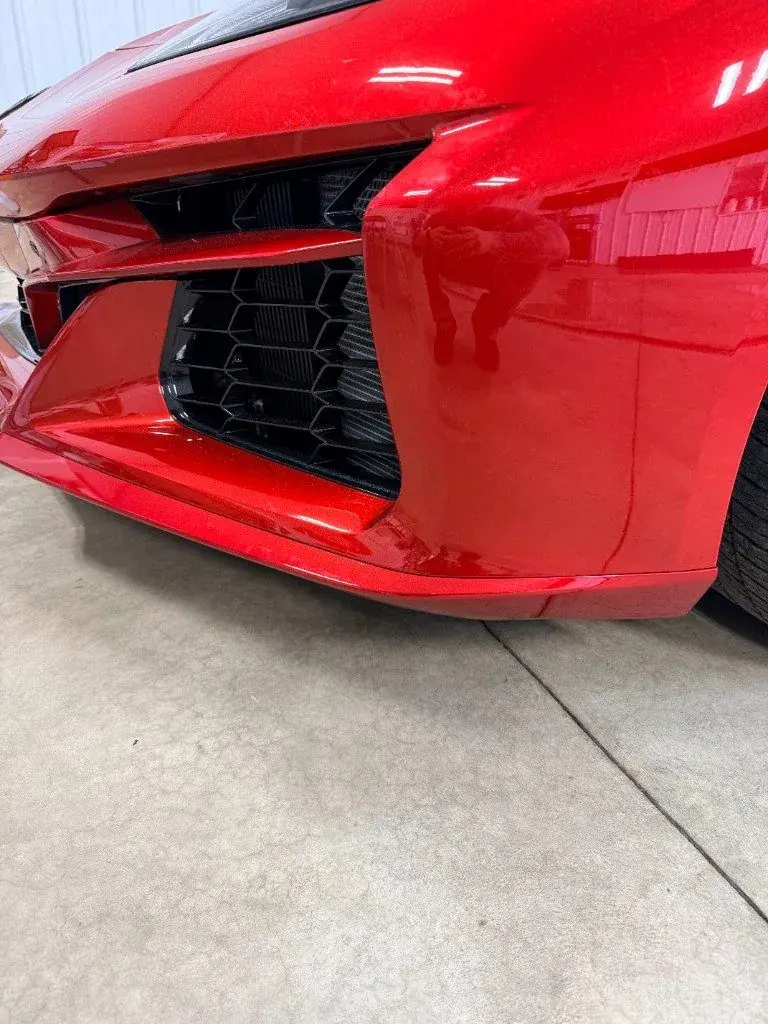 Close up of PPF on a red Corvette bumper