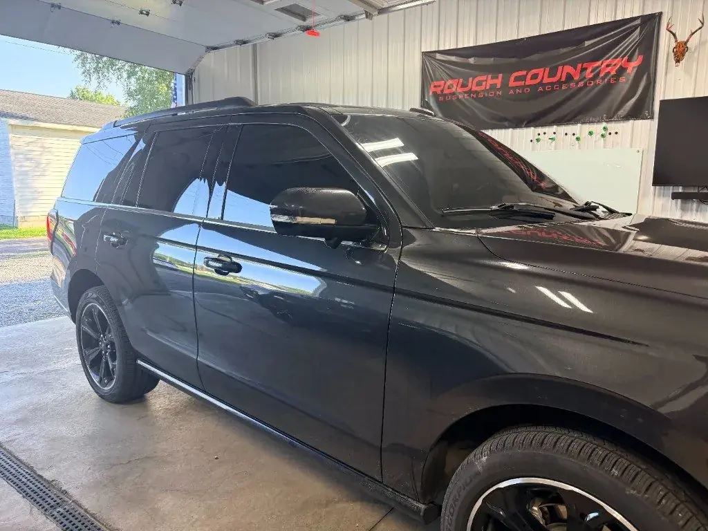 Ford Expedition with tinted windows inside a tint shop