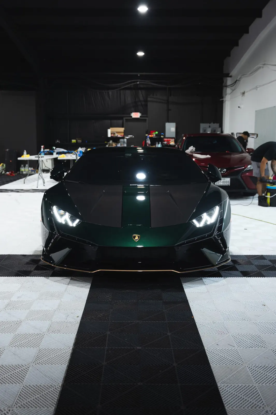 Green Lamborghini with dark ceramic window tint in JLE Customs' shop